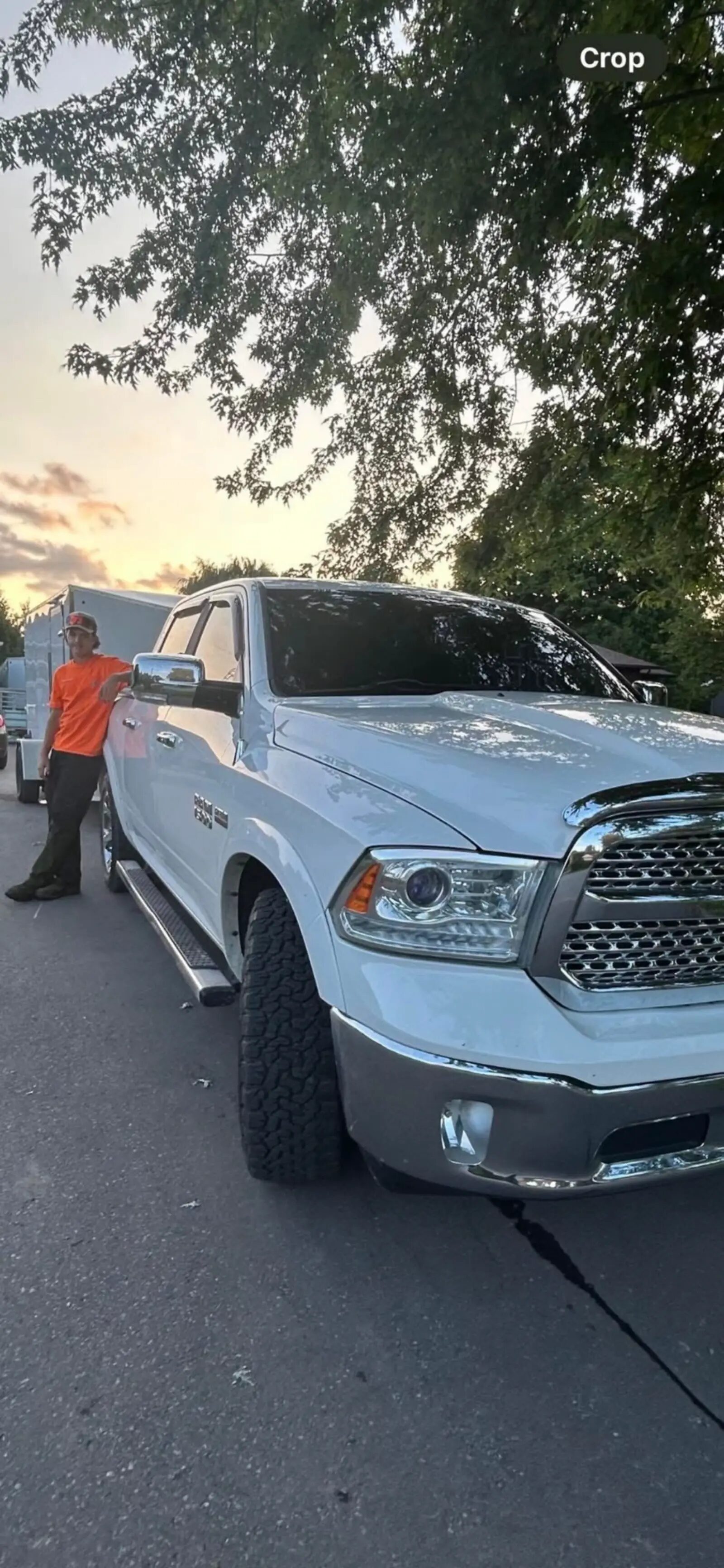 William standing next to his branded truck at sunset